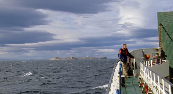 Jirka na přídi lodi Melinka a v pozadí je již vidět ostrov Isla Magdalena, Magalhãensův průliv, Patagonie, Chile