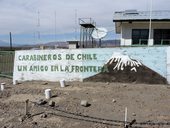 Nápis na betonovém oplocení stanice carabineros v Tacoře - přátelé na hranici - můžeme podepsat!