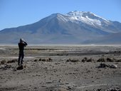 Jirka pozoruje dalekohledem plameňáky, Salar de Suire a sopka Pukintika (5740m), Chile
