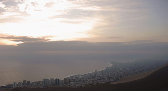 Výhled z výpadovky Alejandro Soria (č. 16) na dunu Cerro Dragón vypínající se nad podvečerním Iquique, Chile