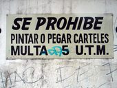 Nápis hlásající, že kreslení a lepení plakátů je trestáno pokutou se ve čtvrti Bellavista, která je plná graffitti nějak neujal, Santiago de Chile