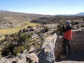 Martin na miradoru (vyhlídka) na modrozelenou stužku řeky Isluga a zeleného bofedalu, NP Isluga, Chile