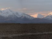 Trojice sopek - čoudící Guallatiri (6071m), uprostřed vykukuje Acontago (6052m) a napravo Capurata (5990m), Chile/Bolívie