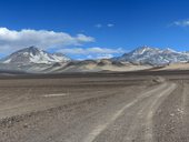 Pista od chaty Lucero k Ojos del Salado (6893m). Nalevo od Ojos del Salado je El Muerto (6488m) a napravo pak Cerro Las Vicuñas (6067m) a ještě blíže Barrancas Blancas (6119m), Chile