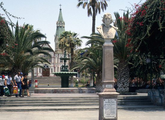 Náměstí Kryštofa Colomba, v pozadí je vidět železná katedrála San Marcos projektovaná kanceláří Gustava Eiffela. Arica, Chile