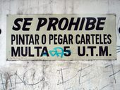 Nápis hlásající, že kreslení a lepení plakátů je trestáno pokutou se ve čtvrti Bellavista, která je plná graffitti nějak neujal, Santiago de Chile