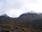 Mraky se částečně trhají a vidíme oba vrcholy Illinizas (ledovcová Illiniza Sur a kamenitá Illiniza Norte), Ekvádor