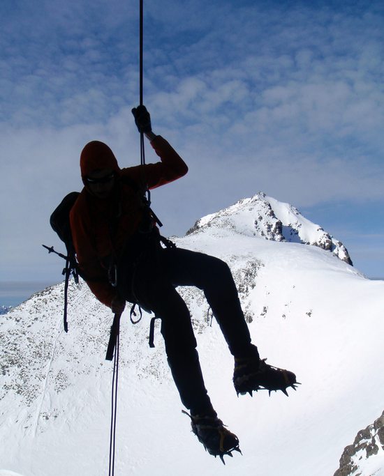 Slanění v převisu z jižního výběžku Ťažkého štítu k chatě pod Rysmi ... za Jirkou se vypíná vrchol Rysů, Vysoké Tatry, Slovensko.