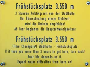Výstražná tabulka označující tzv. Frühstücksplatz - místo kam by měl každý horolezec dorazit nejpozději tři hodiny od nástupu do cesty na chatě Stüdlhütte (3550m).