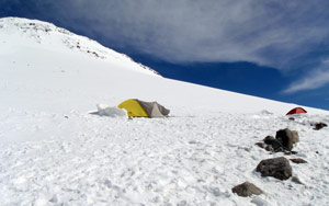 Stany nad Pastuchovými skalami a v pozadí část východního vrcholu Elbrusu, Rusko, 23. července 2009.
